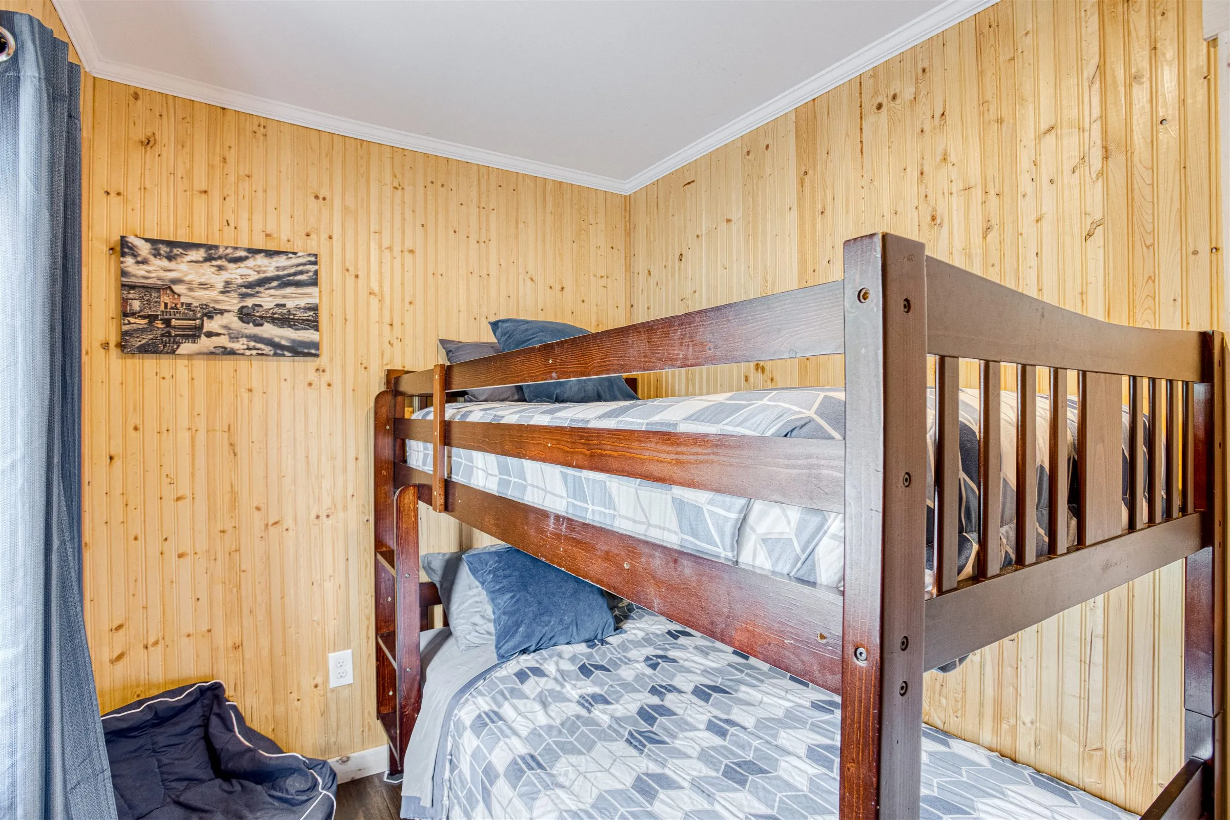 Bunk bedroom with wooden bunk beds and a dog bed for four-legged guests.
