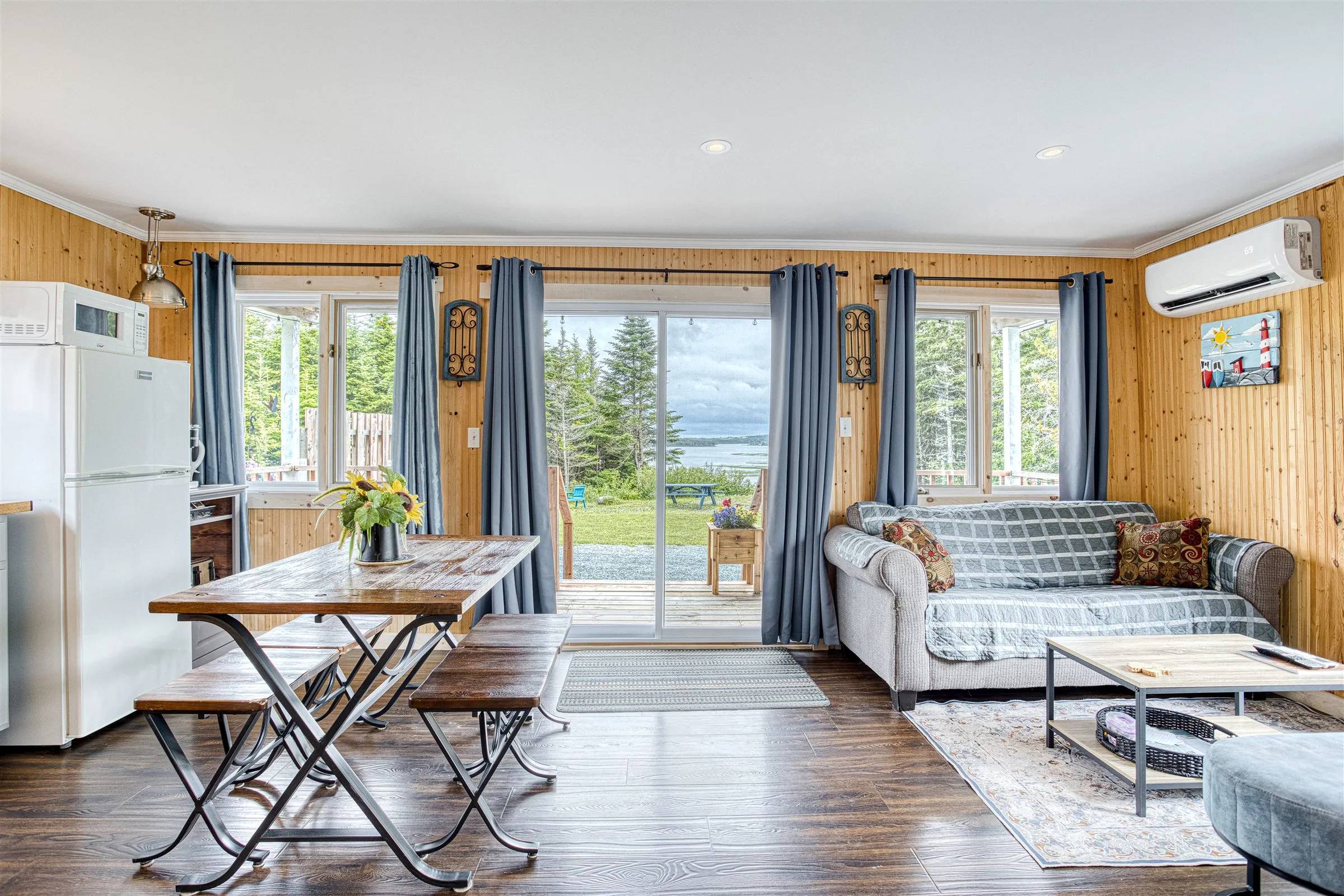 Living room with patio doors opening to the deck and a view out to the inlet.