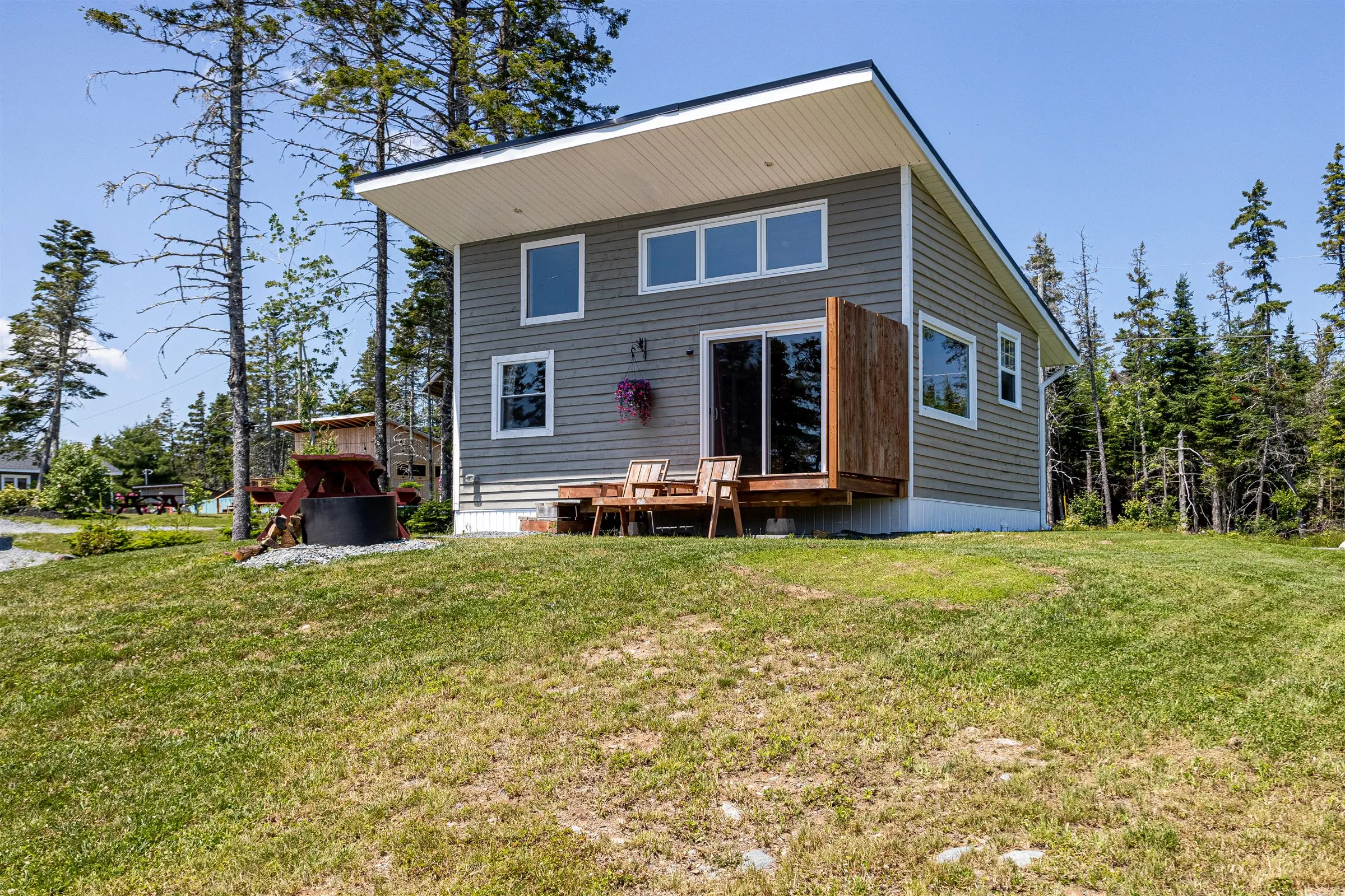 The back porch and deck chairs seen from the sloping lawn.