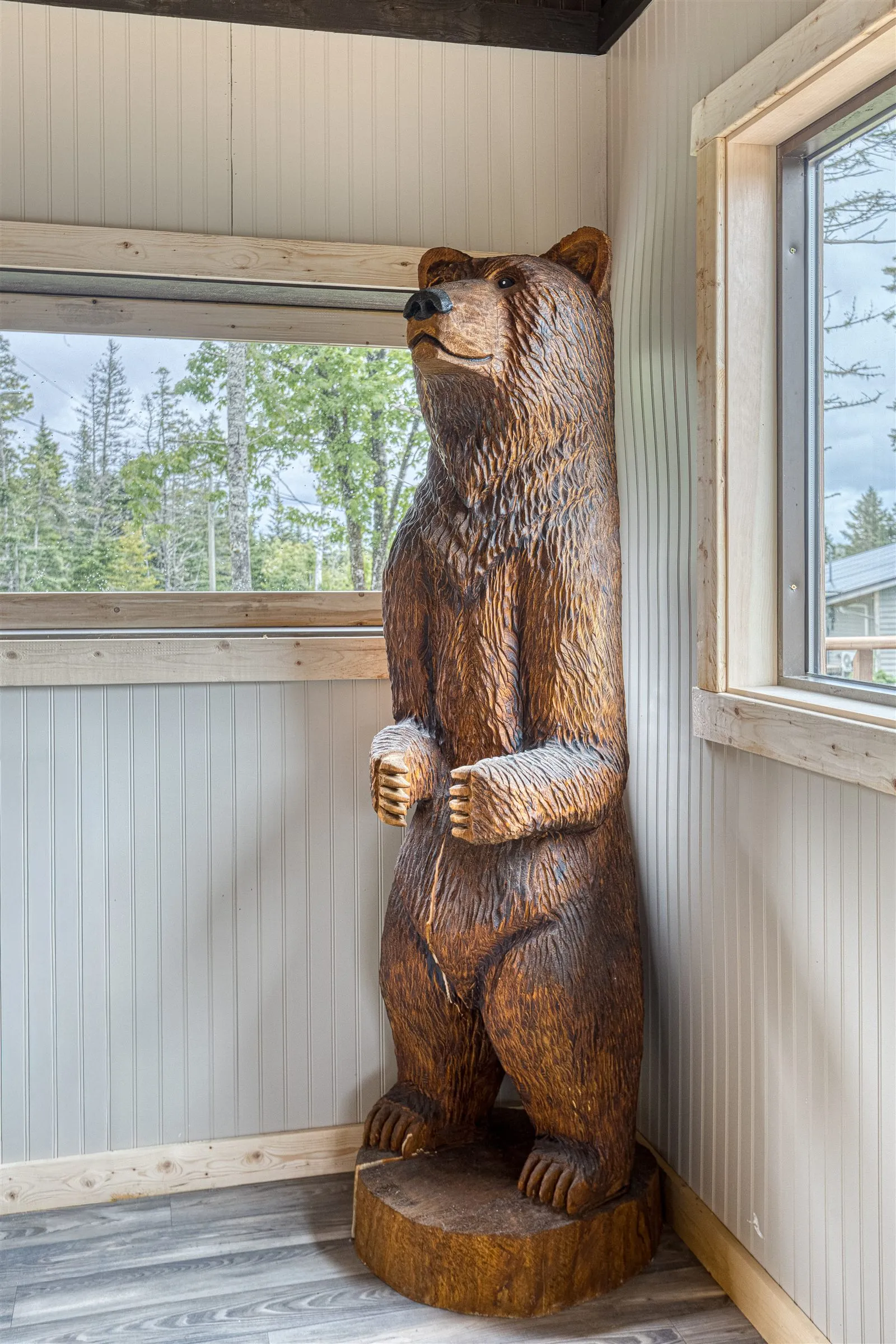 Life-size carved wooden bear standing in a corner of the clubhouse.