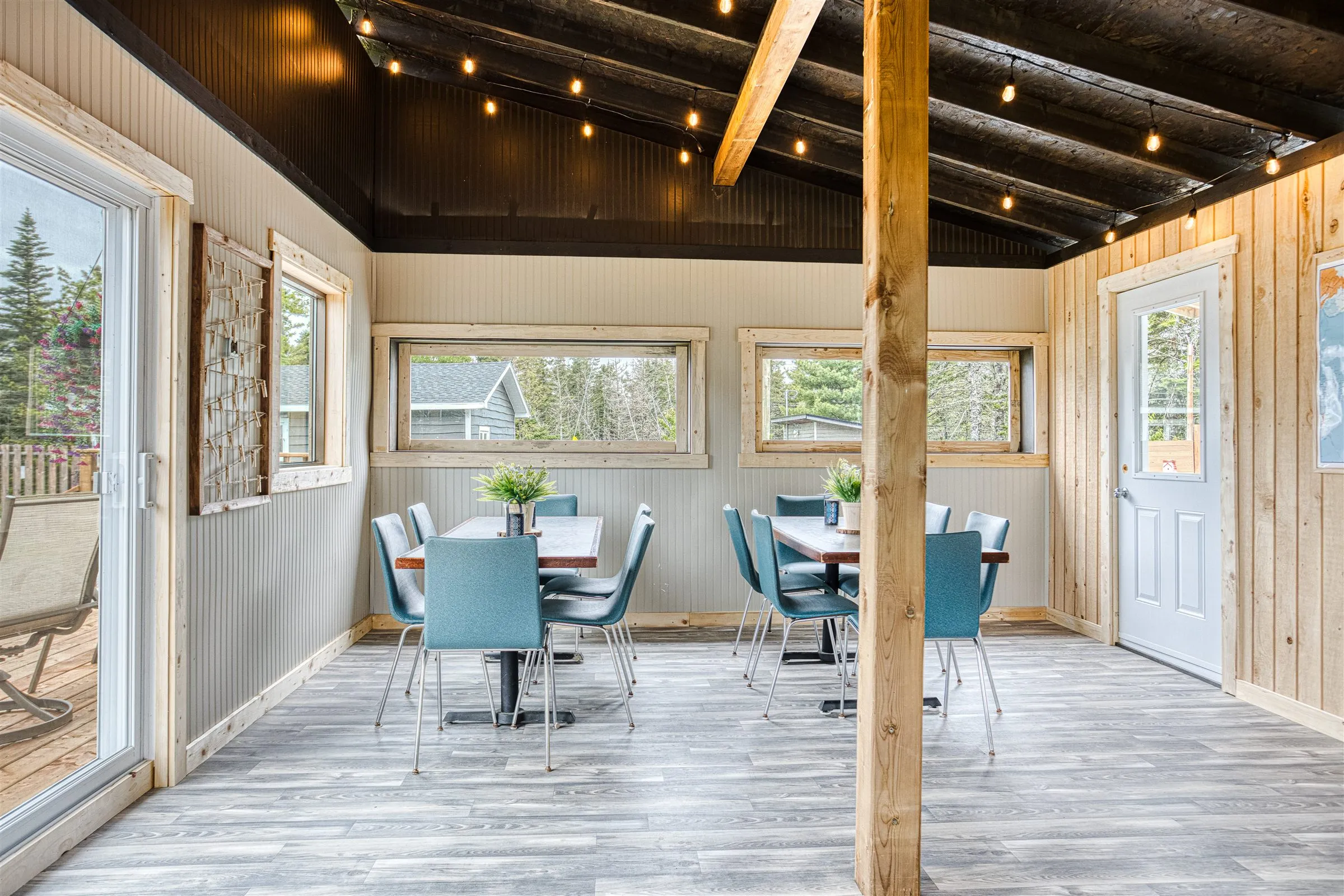 Long shared tables with teal chairs fill the clubhouse dining space.